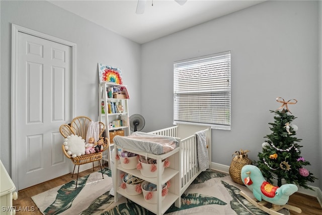 bedroom featuring ceiling fan, baseboards, and wood finished floors