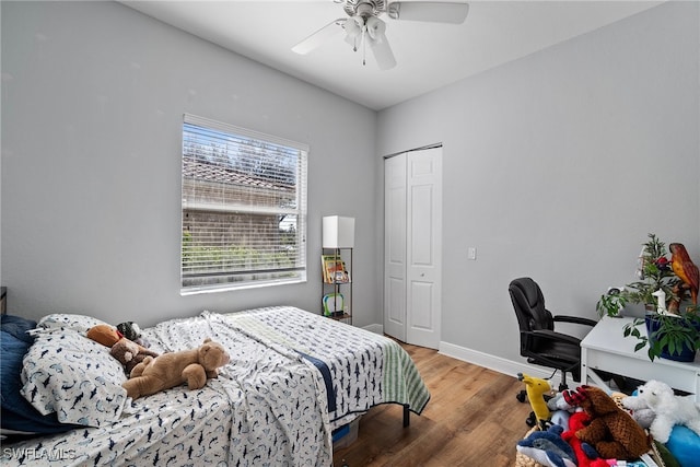 bedroom with a ceiling fan, a closet, baseboards, and wood finished floors