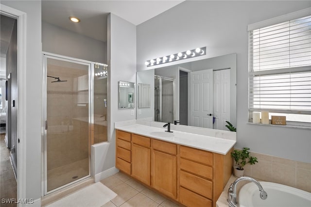 bathroom featuring a stall shower, tile patterned flooring, a garden tub, and vanity