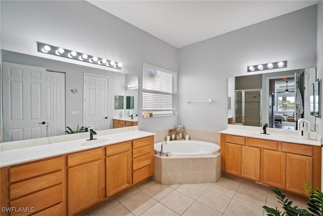 full bath featuring a garden tub, a healthy amount of sunlight, a sink, a shower stall, and tile patterned flooring