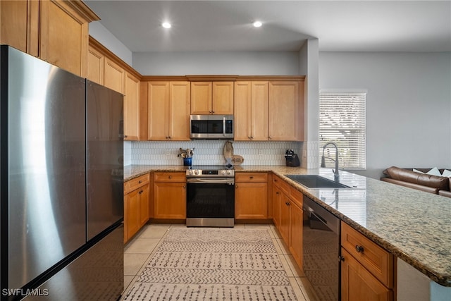 kitchen featuring light tile patterned floors, backsplash, light stone countertops, stainless steel appliances, and a sink