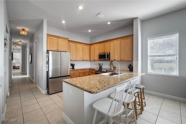 2007 Jacklin Ct, Naples, FL 34120 - kitchen with stainless steel appliances, a sink, light tile patterned flooring, a peninsula, and tasteful backsplash