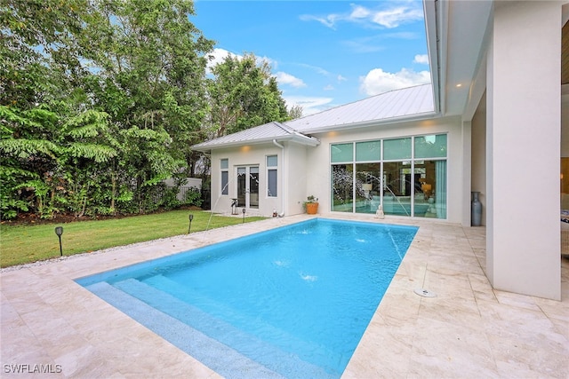 view of pool with a patio area and a lawn