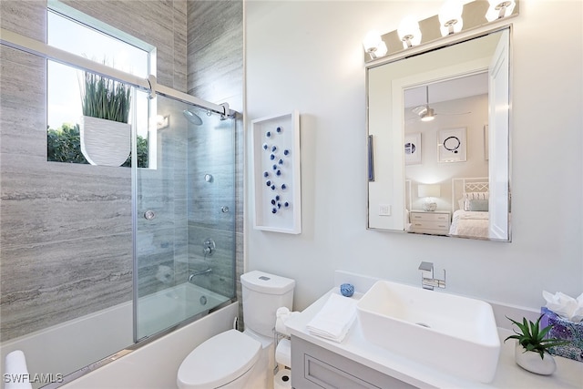 full bathroom featuring ceiling fan, vanity, enclosed tub / shower combo, and toilet