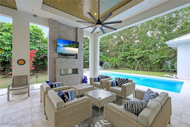 view of patio with an outdoor living space with a fireplace and ceiling fan