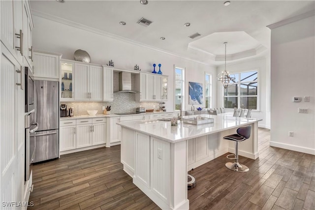 6399 Warwick Ave, Naples, FL 34113 - kitchen featuring wall chimney exhaust hood, freestanding refrigerator, white cabinets, dark wood finished floors, and crown molding