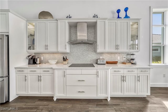6399 Warwick Ave, Naples, FL 34113 - kitchen featuring wall chimney range hood, freestanding refrigerator, white cabinetry, decorative backsplash, and glass insert cabinets