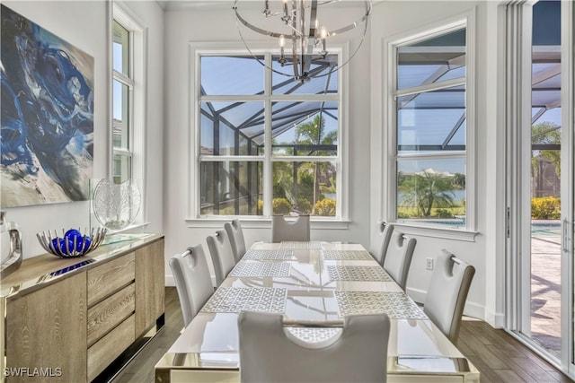 dining room with plenty of natural light, dark wood-type flooring, and an inviting chandelier