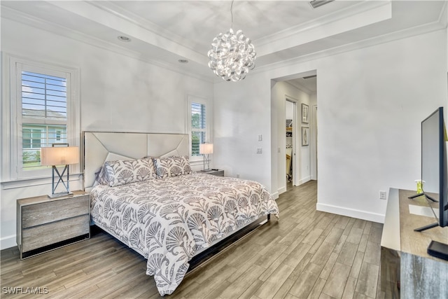 bedroom featuring wood-type flooring, a notable chandelier, and ornamental molding