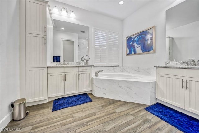 6399 Warwick Ave, Naples, FL 34113 - full bath with two vanities, wood finished floors, a bath, and recessed lighting