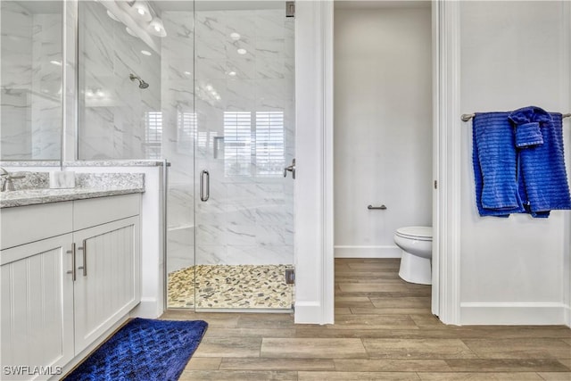 6399 Warwick Ave, Naples, FL 34113 - full bathroom featuring toilet, a marble finish shower, baseboards, vanity, and wood finished floors
