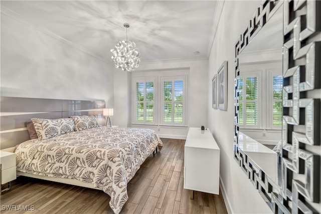 bedroom with a chandelier, crown molding, and wood-type flooring