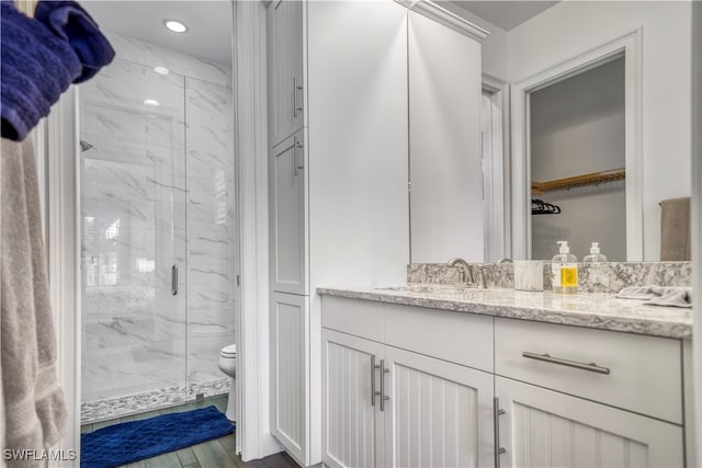 bathroom featuring hardwood / wood-style flooring, vanity, toilet, and an enclosed shower