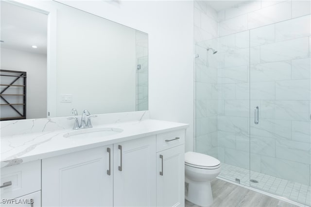 bathroom featuring hardwood / wood-style floors, vanity, toilet, and an enclosed shower