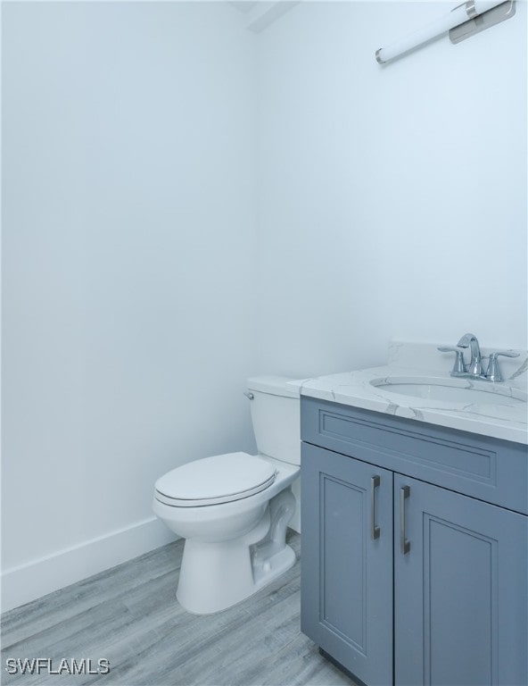 bathroom featuring hardwood / wood-style flooring, vanity, and toilet