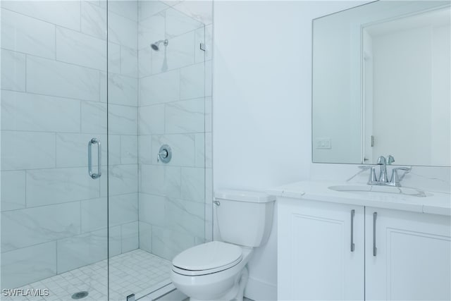 bathroom with vanity, toilet, and a shower with shower door