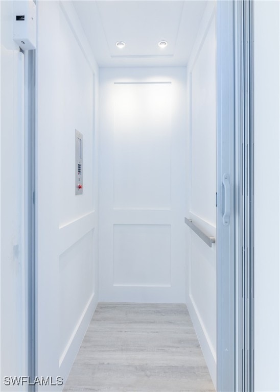 interior space featuring elevator and light hardwood / wood-style floors