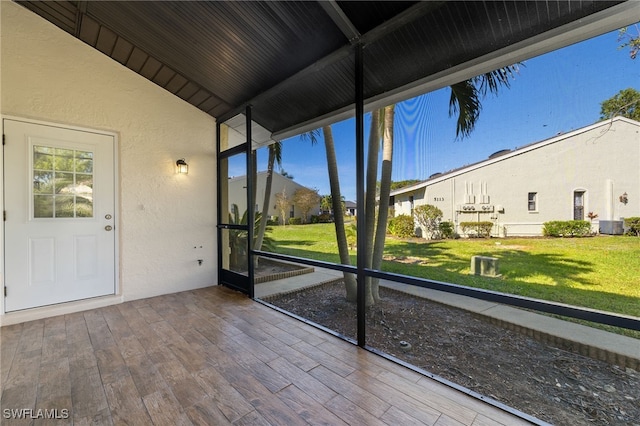 unfurnished sunroom featuring vaulted ceiling with beams