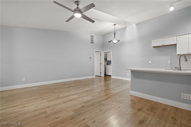 unfurnished living room featuring light hardwood / wood-style floors, high vaulted ceiling, ceiling fan, and sink