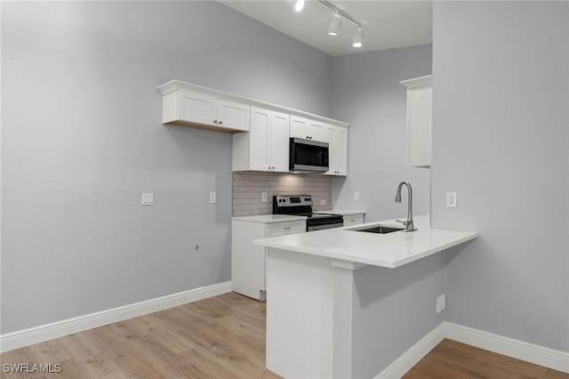 kitchen featuring white cabinetry, sink, stainless steel appliances, light hardwood / wood-style flooring, and decorative backsplash