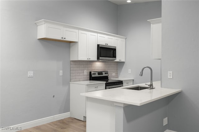 kitchen featuring white cabinets, appliances with stainless steel finishes, backsplash, and sink