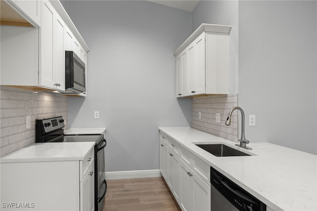 kitchen featuring white cabinetry, sink, light hardwood / wood-style floors, and appliances with stainless steel finishes