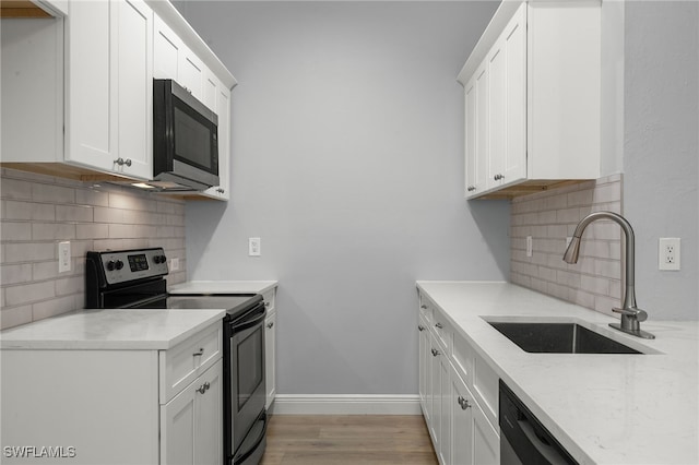 kitchen featuring sink, decorative backsplash, appliances with stainless steel finishes, light hardwood / wood-style floors, and white cabinetry