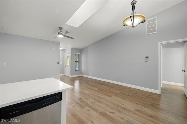 unfurnished living room featuring a skylight, ceiling fan, and light hardwood / wood-style floors