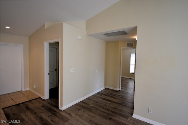 spare room with lofted ceiling and dark wood-type flooring