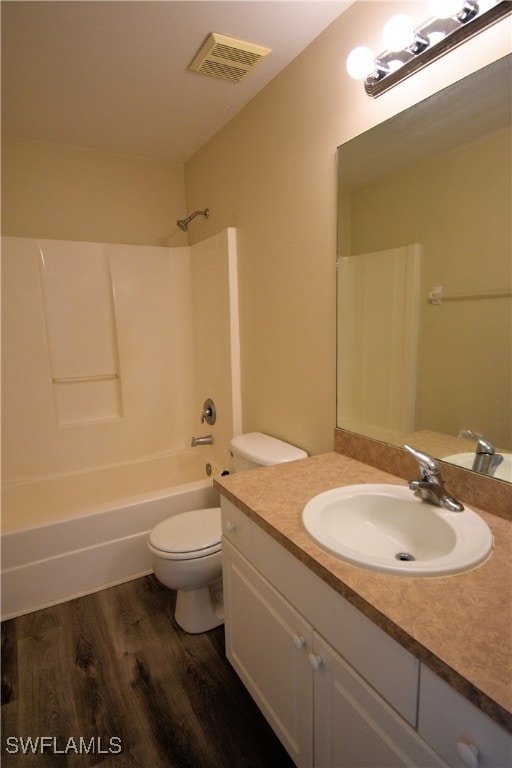 full bathroom with hardwood / wood-style floors, vanity, toilet, and washtub / shower combination