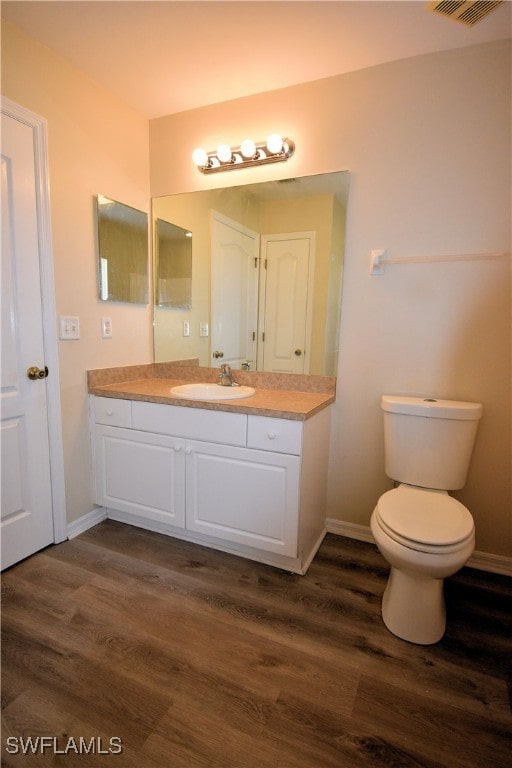 bathroom featuring hardwood / wood-style floors, vanity, and toilet