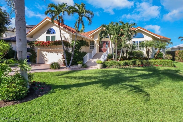 mediterranean / spanish-style home featuring a front yard and a garage