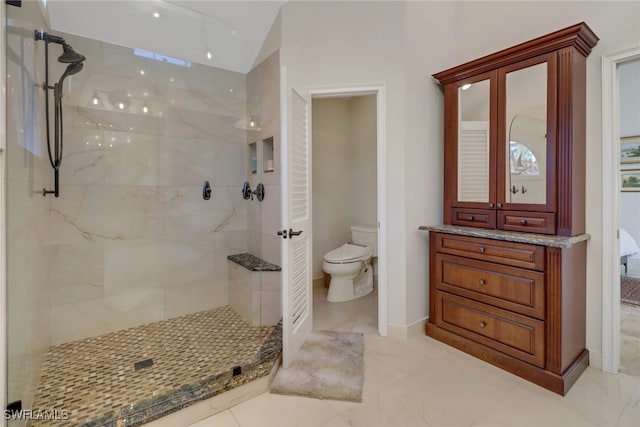 bathroom with toilet and a tile shower