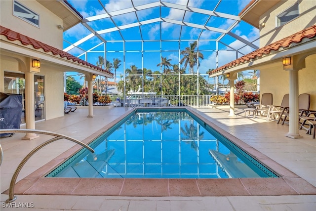 view of swimming pool featuring glass enclosure and a patio area