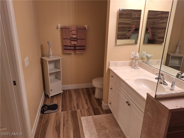 bathroom featuring hardwood / wood-style floors, vanity, and toilet