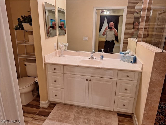 bathroom with a shower, hardwood / wood-style floors, vanity, and toilet