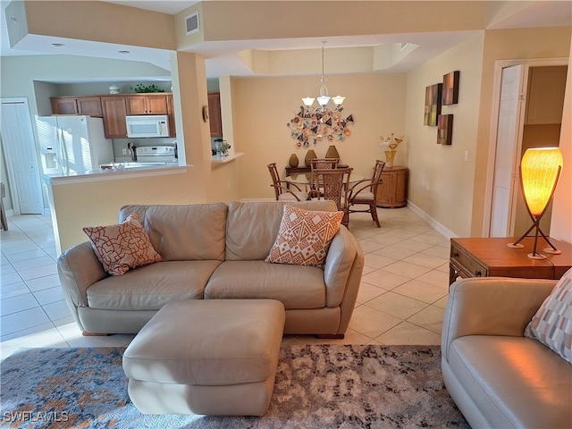 living room with a chandelier and light tile patterned flooring