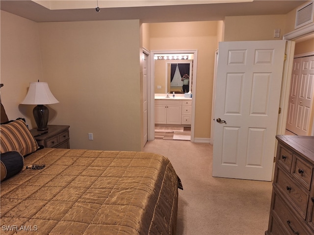 bedroom featuring ensuite bathroom, light colored carpet, and sink