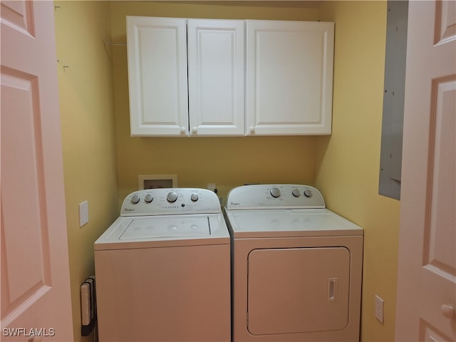 laundry room featuring washer and clothes dryer and cabinets