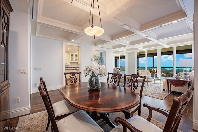 dining room with beam ceiling, ornamental molding, dark wood-type flooring, and coffered ceiling