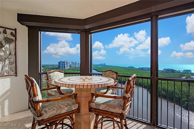 sunroom / solarium featuring a water view
