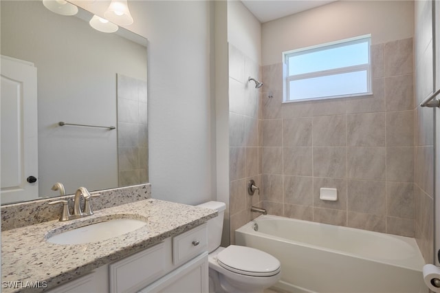 full bathroom featuring vanity, tiled shower / bath combo, and toilet