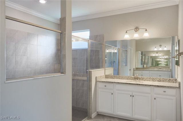 bathroom featuring tile patterned flooring, vanity, a shower with door, and crown molding