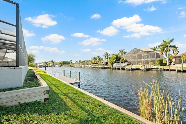 dock area with a lawn, glass enclosure, and a water view