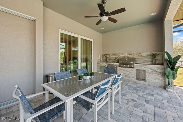 view of patio / terrace featuring area for grilling, ceiling fan, and an outdoor kitchen