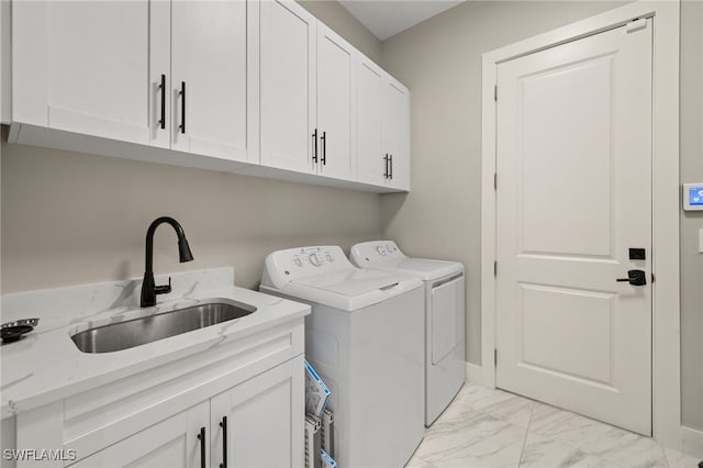 laundry room featuring washer and clothes dryer, cabinets, and sink