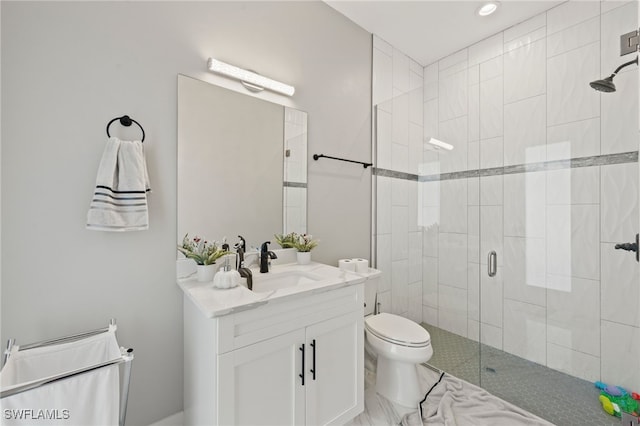 bathroom with vanity, toilet, and a shower with shower door