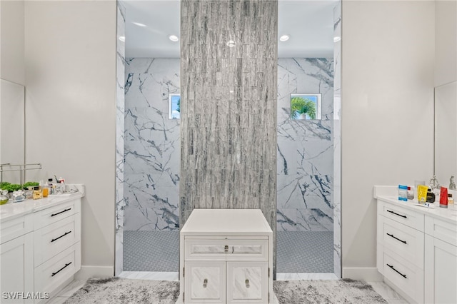 bathroom featuring tiled shower, vanity, and tile walls