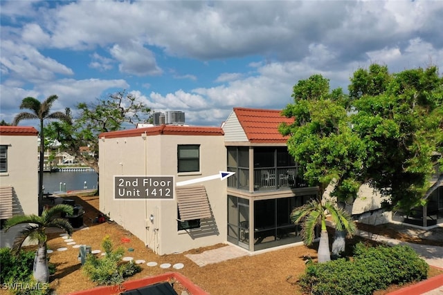 exterior space featuring a sunroom and a water view