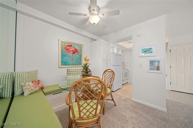 dining space featuring ceiling fan and light carpet